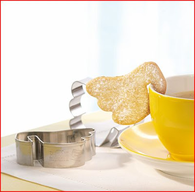 cookie cutter angel wing hanging off of a yellow mug