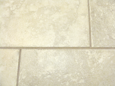 close up of dirty grout on laundry room tile floor before