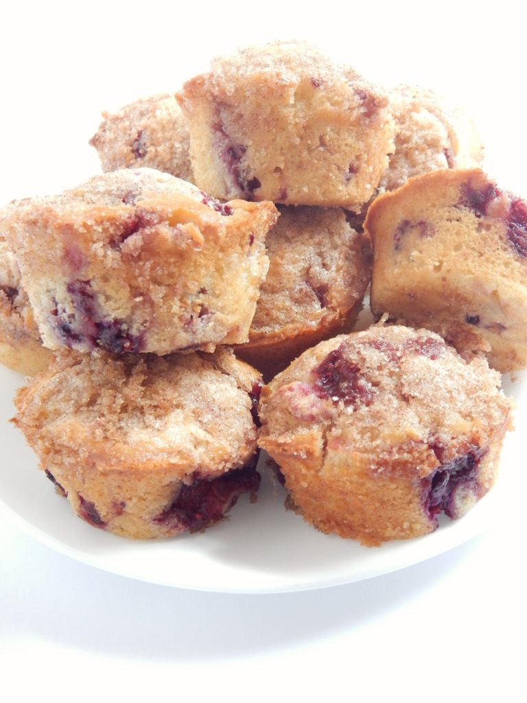 freshly baked raspberry breakfast muffins piled on a plate