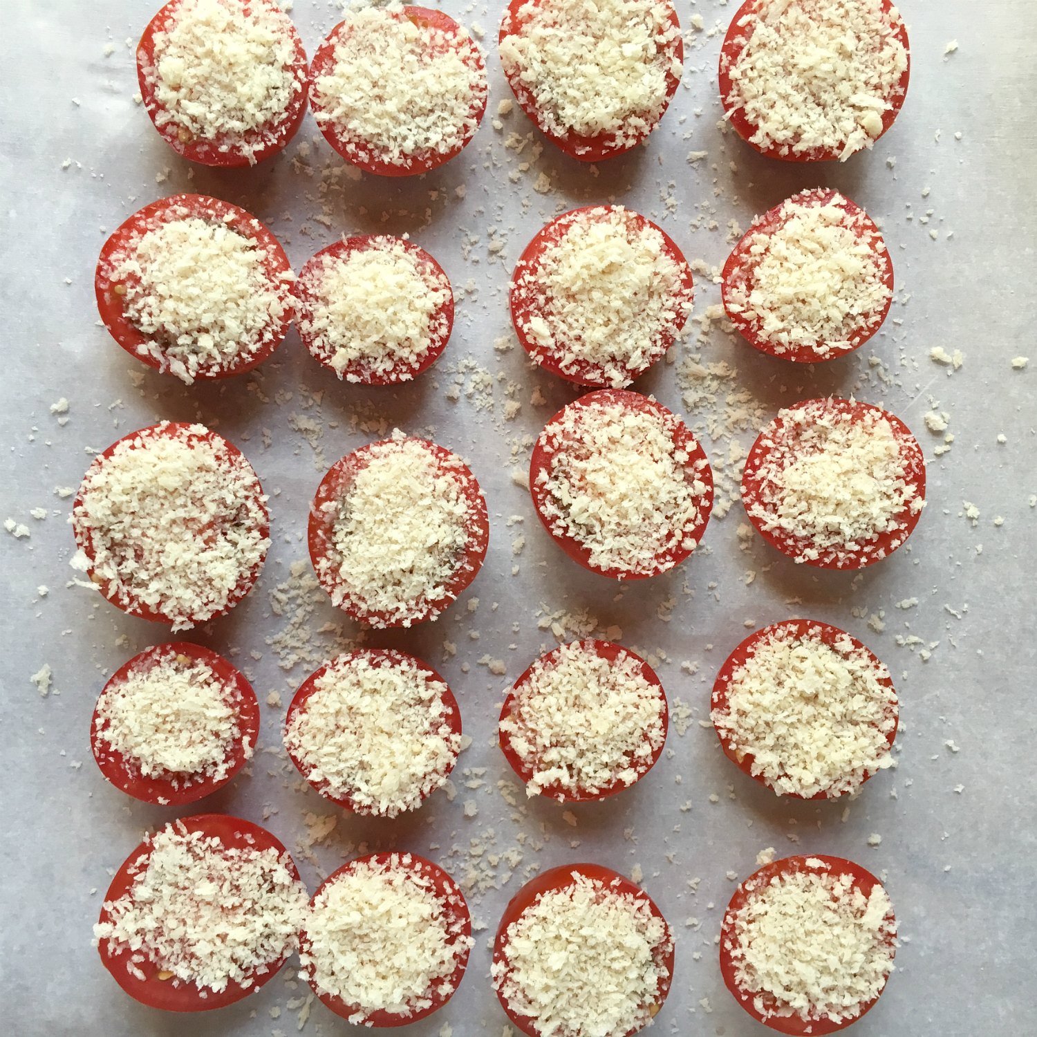 campari tomato halves on parchment paper topped with parmesan and panko bread crumbs panko parmesan tomatoes