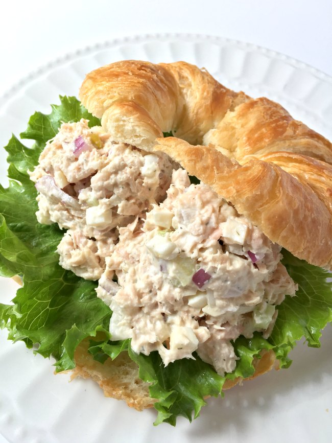 tuna salad sandwich with lettuce on croissant
